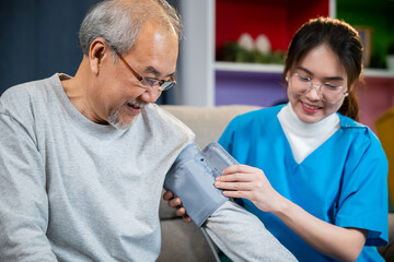 Obraz premium Asian nurse visit patient senior man at home she measuring arterial blood pressure on arm in living room, Doctor woman examine do checking old man client heart rate with pulsimeter monitor, Healthcare