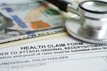 Health claim form with stethoscope and US dollar banknotes, insurance accident medical concept.