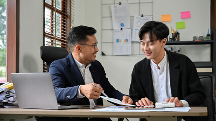 Professional Asian male financial analyst or male boss working with his staff.