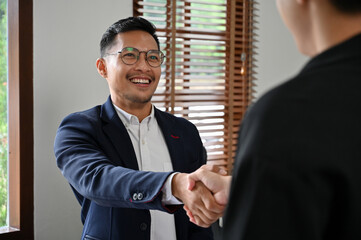 Fototapeta premium Successful Asian businessman shaking hand with his business partner in the meeting.