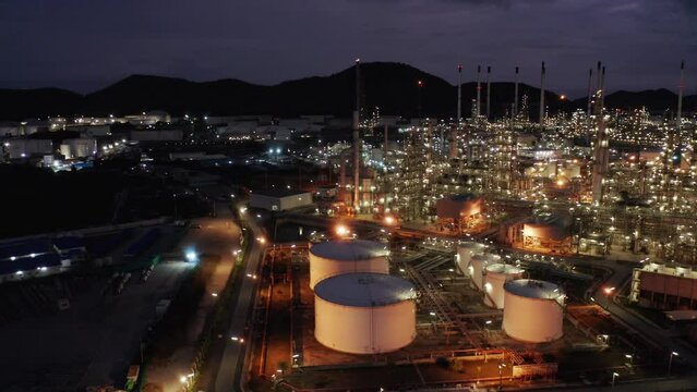 Aerial view drone flying with light oil terminal is industrial facility for storage of oil and petrochemical. oil manufacturing products. power electric plant. low light. Refinery b roll drone shot 4k