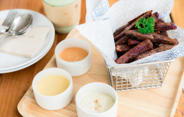 Fried sweet purple potato food, fried Japanese purple sweet potato with dips in a wooden tray