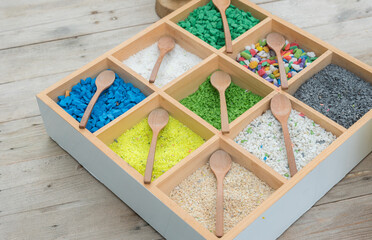 Colored pebbles mini stone and wooden spoons are in wooden boxes for used terrarium