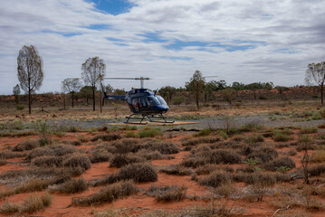 Passengers getting ready for a helicopter ride on a cloudy day at Ayers Rock Uluru-Kata Tjuta in Northern Territory, Australia. Valley of the winds