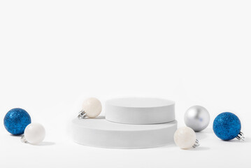 Cosmetic background for Christmas and winter holiday. White podium, christmas balls and snow on...