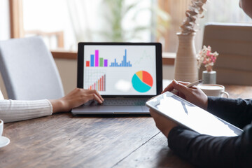 Two businessmen talking in a board room about joint business and summarize the company's profits with a graph showing successful performance. A colleague reviewed the results of the quarterly report.