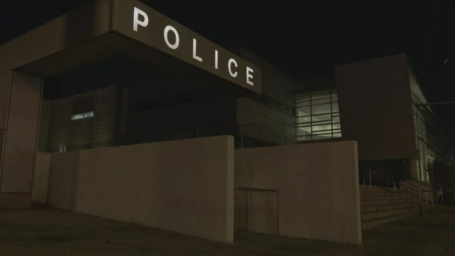 Police station logo and sign lit up at night. Law enforcement building