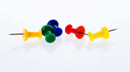 Many colored thumbtacks on white background