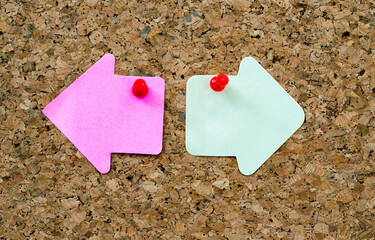 Arrow shape sticky notes on cork board