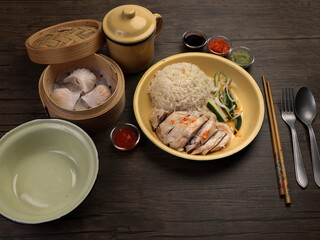 steamed Hainanese chicken rice crystal har gow transparent prawn shrimp meat stuffed dim sum in bamboo steamer green red chilli ginger soya sauce cucumber carrot on retro enamel diner plate fork spoon