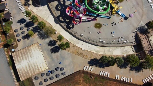 aerial footage of the city of Warner Robins Georgia with restaurants, offices buildings,  warehouses and a water park surrounded by vast miles of lush green trees with a gorgeous clear blue sky
