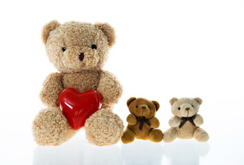 Teddy bears family with red heart sitting in a line against white backghround