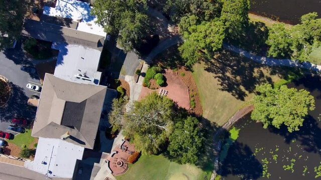 aerial footage of a gorgeous autumn landscape at Houston Lake with rippling blue water surrounded by lush green trees, grass and plants with a golf course and homes along the banks in Warner Robins