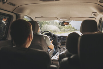 Young man holding steering wheel while driving car. Road trip. Local travel concept. Thirst for adventure.