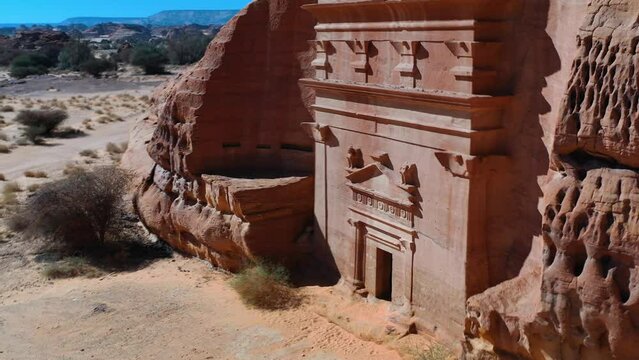 Aerial view around a tomb at Hegra Archaeological Site in sunny Saudi Arabia - circling, drone shot