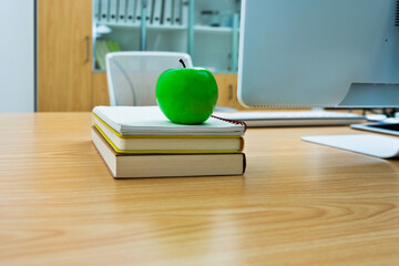 Green apple on desk of office room