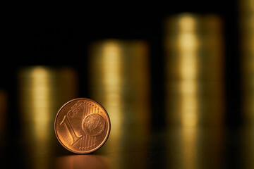 Close-up of one cent euro coin on the background of stacks of coins