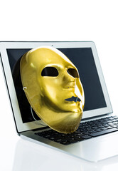 Golden mask on laptop against white background