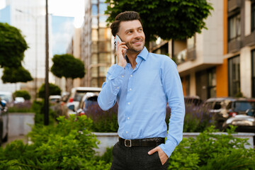 Bristle man wearing shirt talking on mobile phone at street