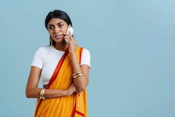 Young beautiful indian woman in traditional dress talking phone