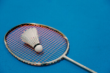 Badminton and shuttlecock isolated on blue badminton court background.