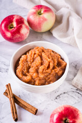 Homemade applesauce in a bowl and fresh fruit on the table. Organic food. Vertical view
