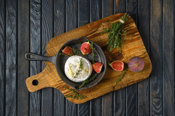 Overhead view of baked camembert cheese and figs on frying pan