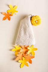 Autumn decoration. The image of a gnome from a fabric cap, paper leaves and a pumpkin