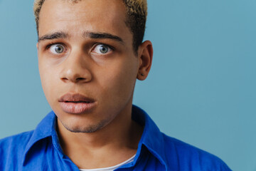 Fototapeta premium Blonde scared man wearing shirt expressing surprise at camera