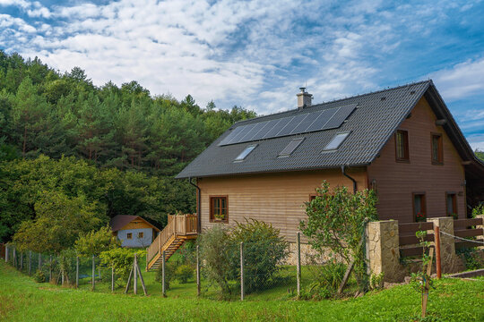 Wooden house with installed solar panels. Alternative energy, saving resources and sustainable lifestyle concept.