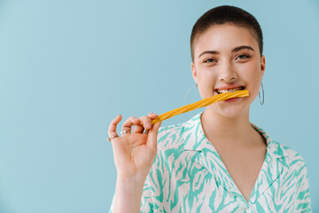 Young woman wearing shirt smiling and eating candy gummy