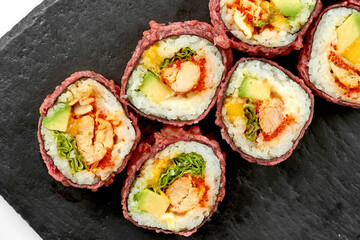 Sushi rolls with shrimp and avocado in a plate on a white background. Close-up. Selective focus