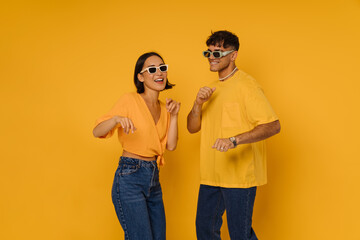 Young beautiful smiling happy couple in sun glasses dancing