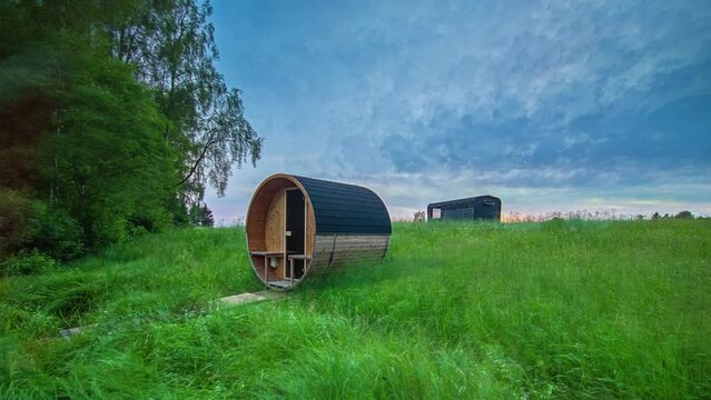 Timelapse shot of wooden holiday cabin and barrel sauna from summer to cold winter season.