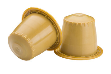 Two yellow capsules with ground coffee, for a capsule coffee machine, on a white background, one capsule is overturned, isolate