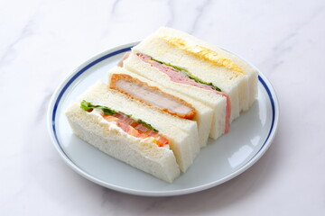 トンカツやタマゴ、ハム、生野菜のサンドイッチ