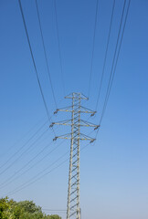 high voltage power pole and lines against the blue sky