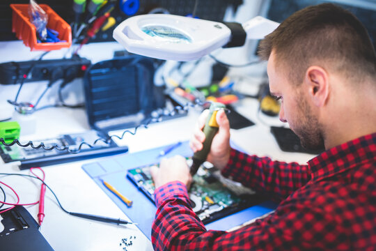 IT engineer technician repairing computer in electronics service shop
