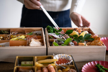 おせち料理を取り分ける女性の手元