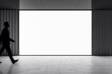 Dark man silhouette walking by big blank white screen with space for your logo or text in abstract...