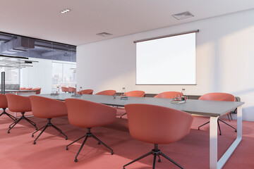 Perspective view on blank white projector screen with place for your logo or text on light wall in spacious conference room with grey meeting table and red chairs around. 3D rendering, mockup