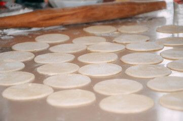 Fototapeta na wymiar Dough for homemade pelmeni on table. Process of making pelmeni, ravioli or dumplings with meat.
