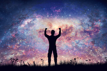Happy man with hands up on night sky with nebula and stars