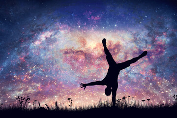 Happy man doing cartwheel on night sky with nebula and stars