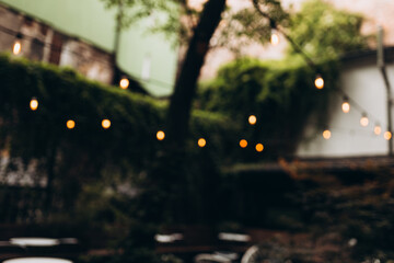 Decorative outdoor string lights at night time, Defocused Background, night city life backdrop,...