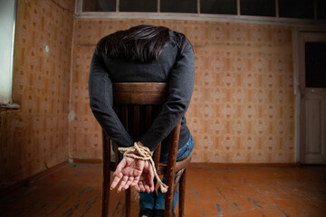 Woman tied up sitting on a chair