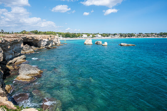 beautiful cliff with clear and crystalline turquoise water in Sicily in Syracuse with the beach of Fontane Bianche in the background