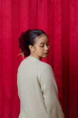 Portrait of cheerful beautiful Asian Woman in casual shirt. Beautiful asian female model posing in studio on red background.