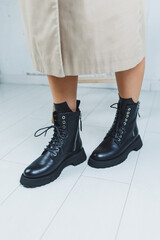 Fashionable leather lace-up boots on female feet, close-up, fashionable. New collection of leather autumn women's shoes