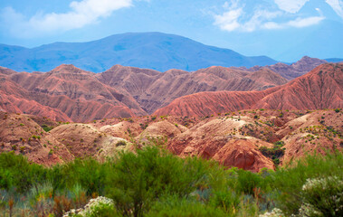 Natural unusual landscape of red rocks against the backdrop of blue mountains. The extraordinary beauty of nature is similar to the Martian landscape. Amazingly beautiful landscape.